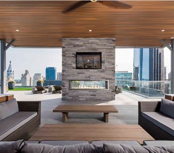 Fully furnished roof deck with panoramic views, outdoor fireplace, and grills